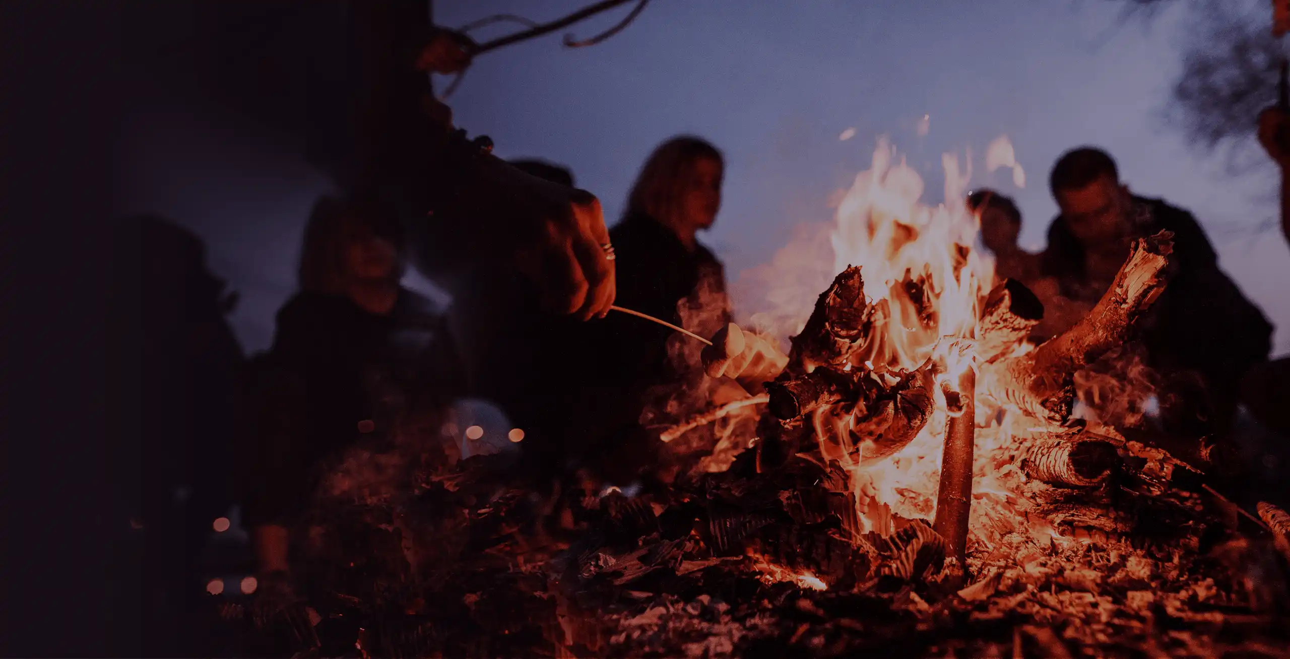 Menschen sitzen um ein Lagerfeuer